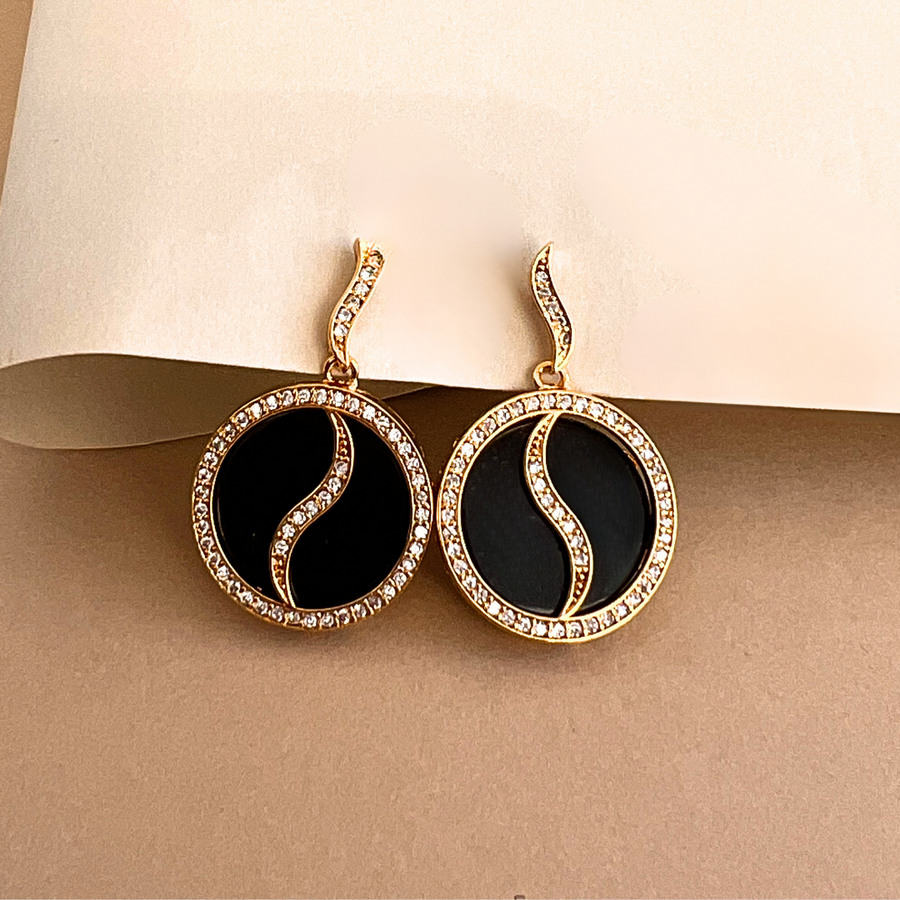 Elegant black and gold earrings adorned with dazzling diamonds, a luxurious accessory for any occasion.