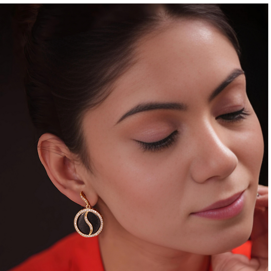 A woman wearing a gold earring with a circle design, adding elegance and sophistication to her appearance.
