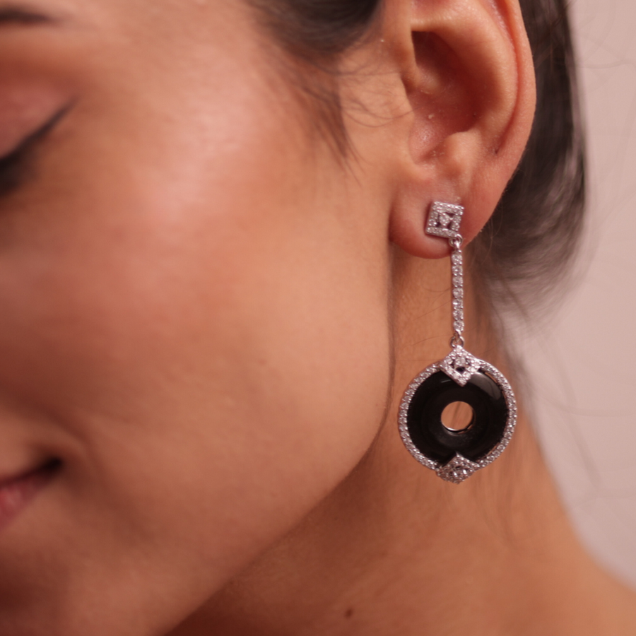 A woman wearing elegant black and white earrings, adding a touch of sophistication to her attire.