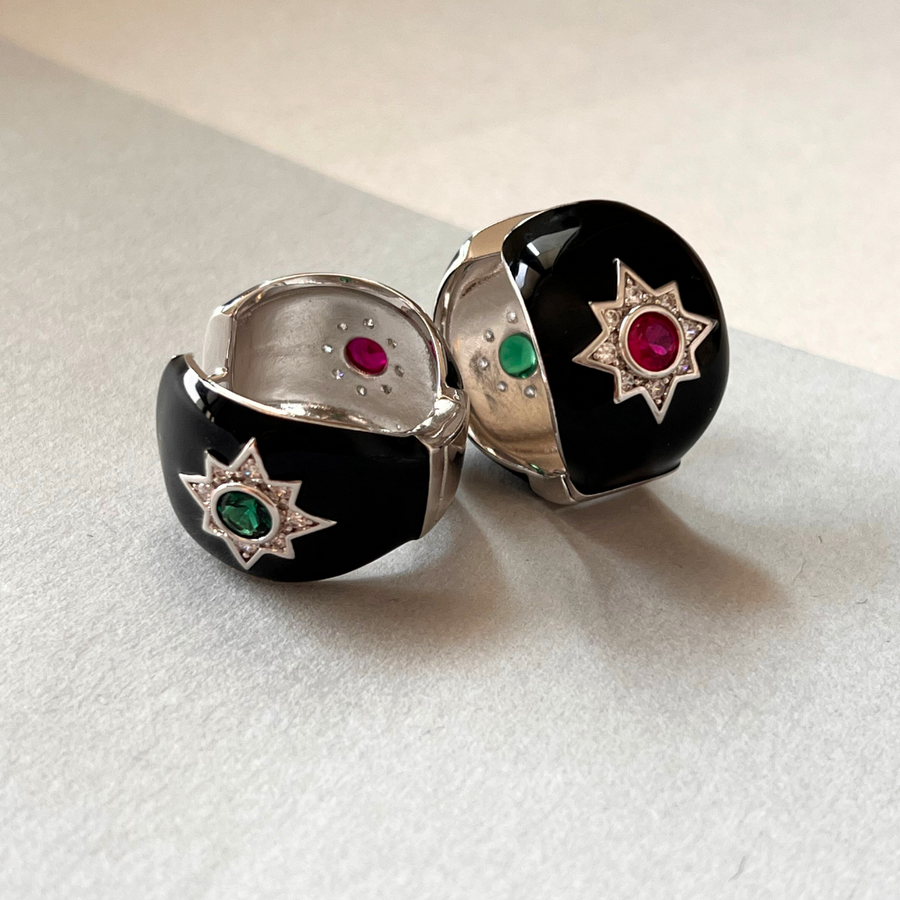 Two rings with black and white bands, adorned with green and red stones.
