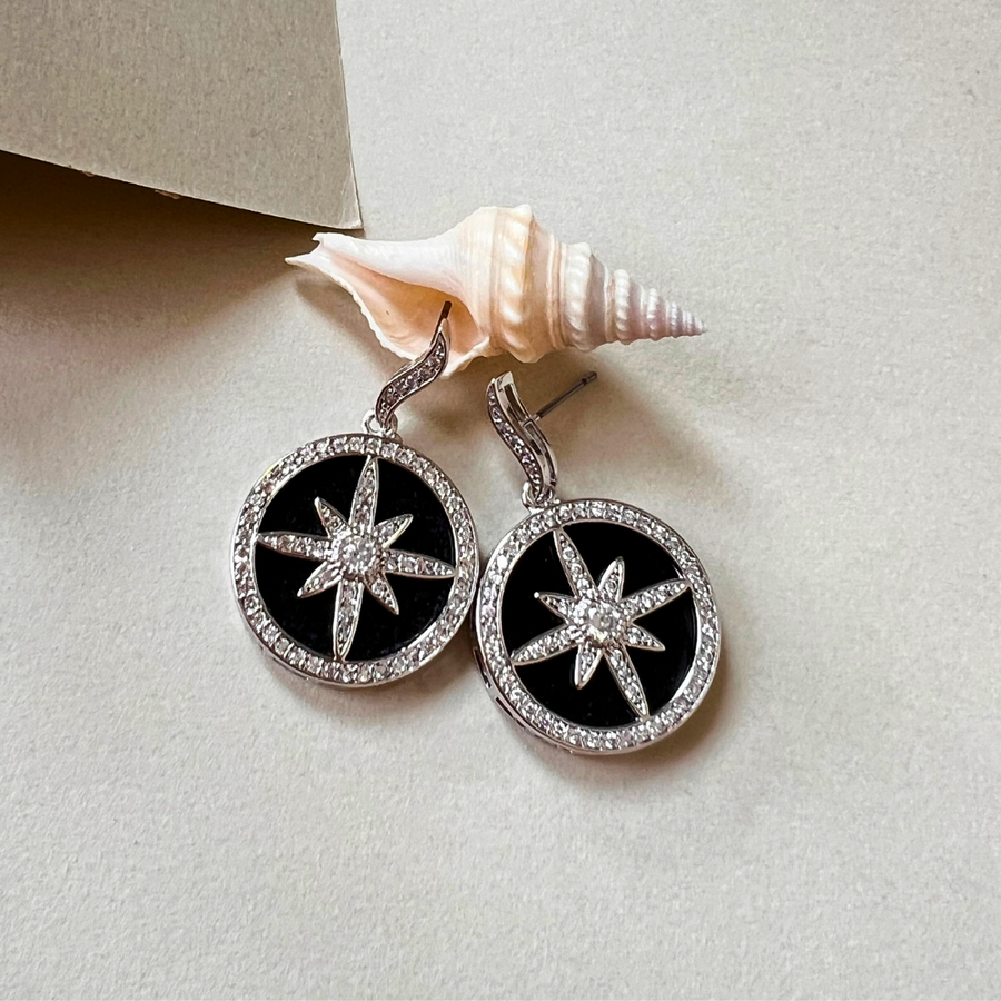 A pair of earrings featuring a star and a shell design, perfect for adding a touch of elegance and nature-inspired beauty to any outfit.
