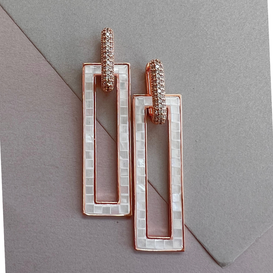 Two square earrings with white enamel and diamond accents, perfect for adding elegance to any outfit.
