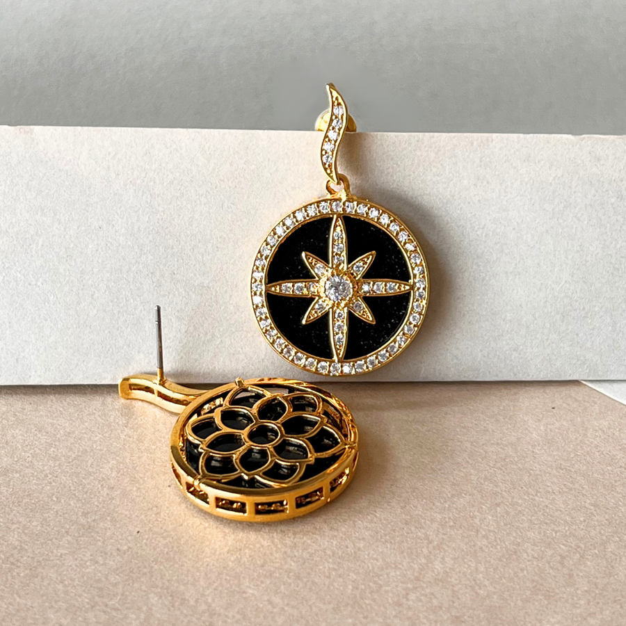 A pair of gold and black earrings featuring a star and a moon design, adding elegance to any outfit.