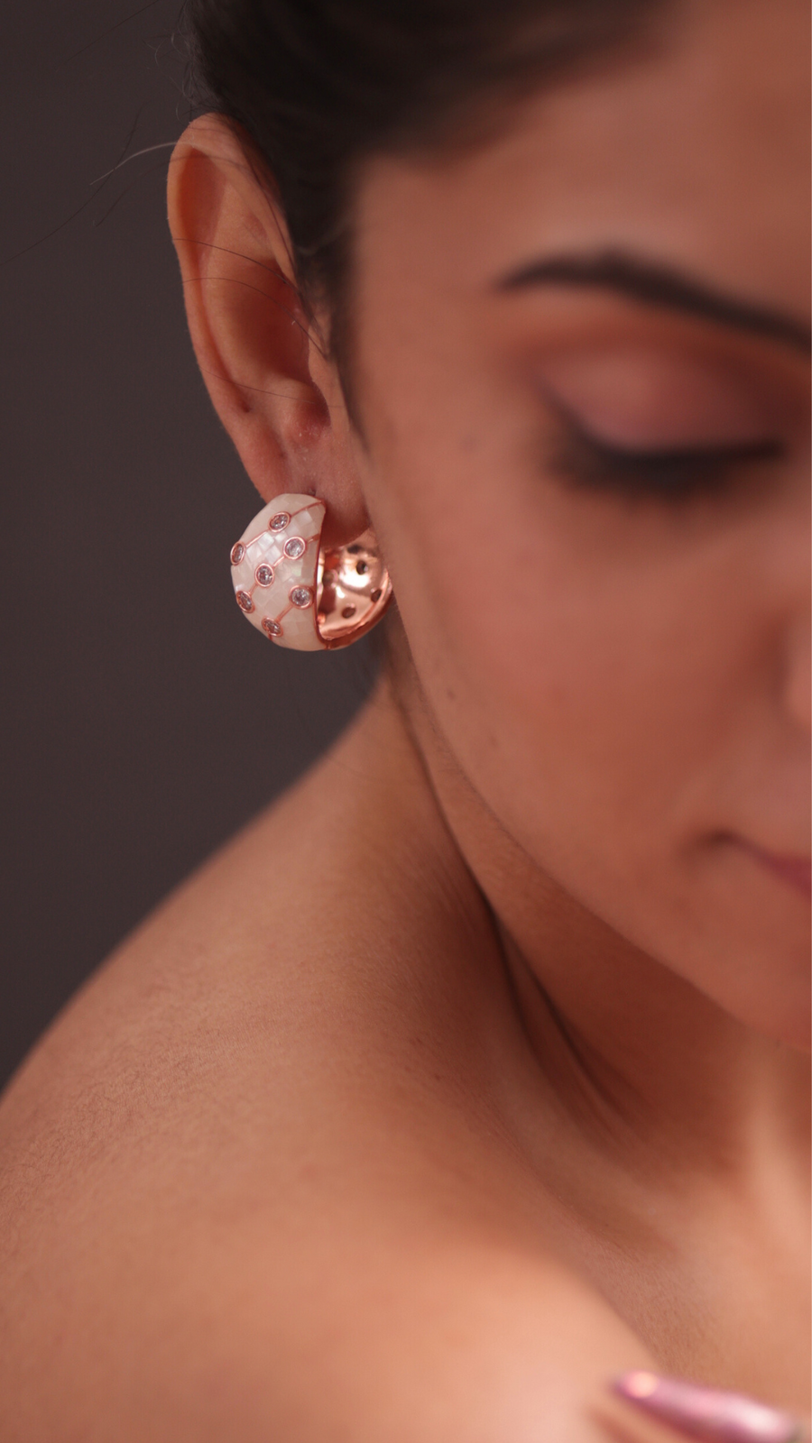 A woman wearing shell earrings, adding a touch of nature-inspired elegance to her outfit.