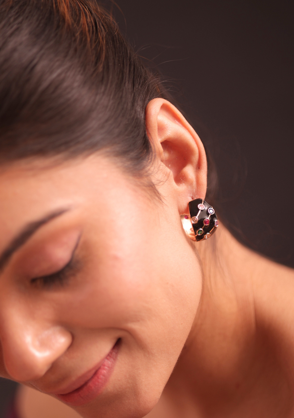 A woman in a purple dress and adrisya earrings, looking elegant and stylish.