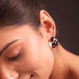 A woman in a purple dress and adrisya earrings, looking elegant and stylish.