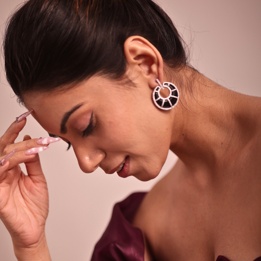 mage of a lady with hand on face, showcasing beautiful earrings.
