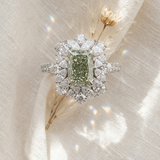 Diamond ring with a green gemstone on a soft fabric background