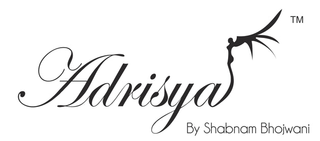 Elegant script logo reading "adrisya" with a stylized dancer figure forming the letter "a," followed by "by Shabnam Bhojwani" and a trademark symbol on the right.