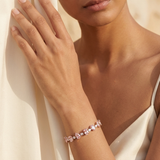 Woman wearing a pink bracelet against a neutral background