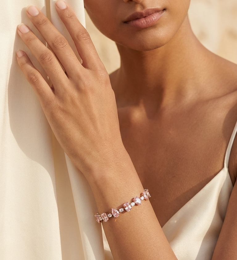 Woman wearing a pink bracelet against a neutral background