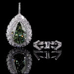 Teardrop-shaped gemstone pendant with diamond accents on a black background
