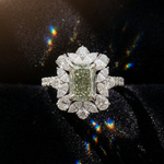 Diamond ring with a green gemstone on a black background
