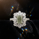 Diamond ring with a green gemstone on a black background